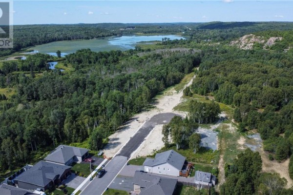Panoramic view of a developing neighborhood with new homes, bare lots, and a distant blue lake. - Lot 1 Herman Mayer Drive, Lively