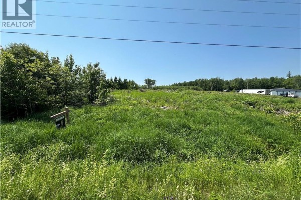 Snowy terrain featuring sparse grass and distant structures under a partly cloudy sky. - Lot 1 Route 620, Hamtown Corner