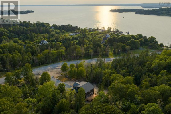 Aerial view of a wooded property covered in snow with a body of water in the distance. - Lot 102 Peggys Cove Road, French Village