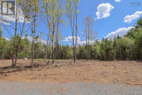 Cleared land with dirt, stones, and scattered young trees under a blue sky. - Lot 107 Cleversey Ridge Park, Fauxburg