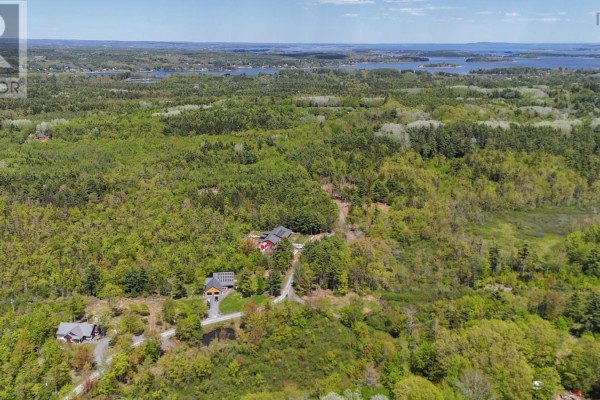 Aerial view of a forested area with scattered homes and a distant body of water. - Lot 107 Cleversey Ridge Park, Fauxburg