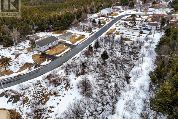 Aerial perspective of a rural street bordered by snow, trees, and residential buildings. - Lot 11 Shaheen Crescent, Come By Chance