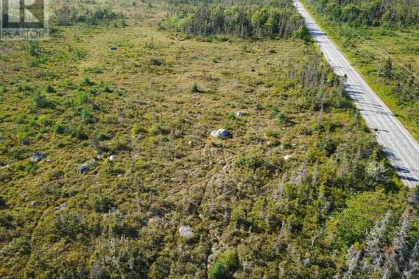 Aerial view of a large parcel of land with scattered rocks and trees along a road. - Lot 12, Swaines Road, Port Clyde