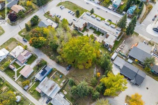 Drone view of the Rossland lot surrounded by mature trees and neighboring homes. - Lot 13-20 Third Avenue, Rossland