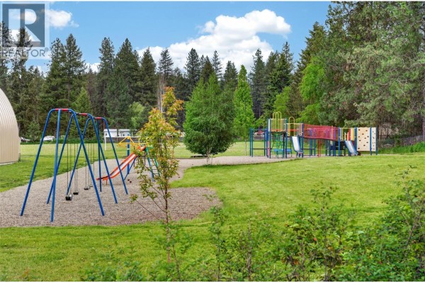 Aerial view of a wooded, irregularly shaped lot outlined in white, bordered by a paved road. - Lot 14 Caitlin Road, Christina Lake