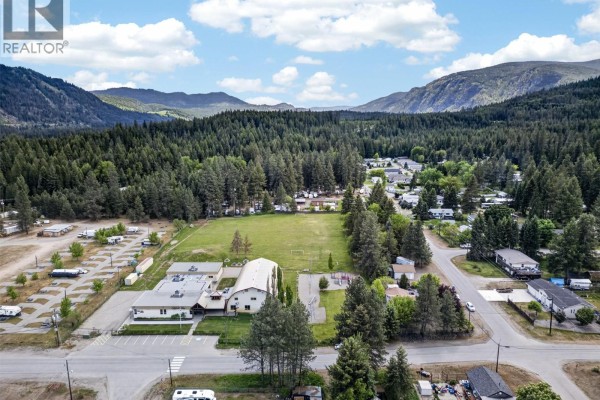 A wooden boardwalk leads to a lake with boats, docks, and buildings along the shoreline. - Lot 14 Caitlin Road, Christina Lake