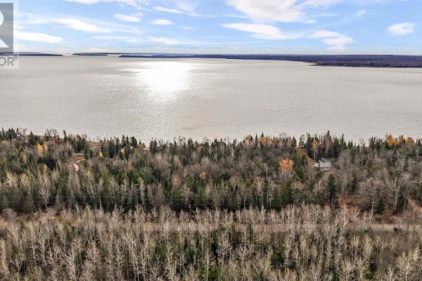 Wide view of the lake with forested land in the foreground and sunlight reflecting on the water. - Lot 17 Ellwood Blvd, Hilton