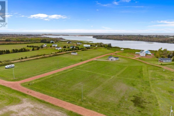 Aerial view of cleared land parcels with scattered homes and a distant water view. - Lot 17 Majestic View Lane, Lakeside