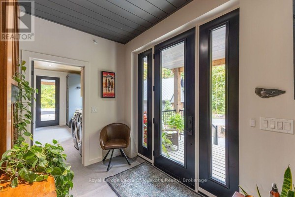 Foyer with gray tile floors, black-framed doors, and a leather accent chair. - Lot 18 - 113 Gryffin Bluffs Lane, Huntsville