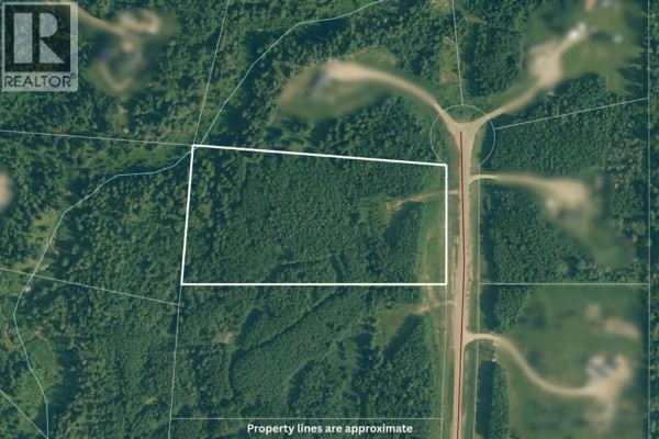 Aerial view of a property lot outlined in white, adjacent to a paved road. - Lot 19 Mountain Springs, Rural Woodlands County