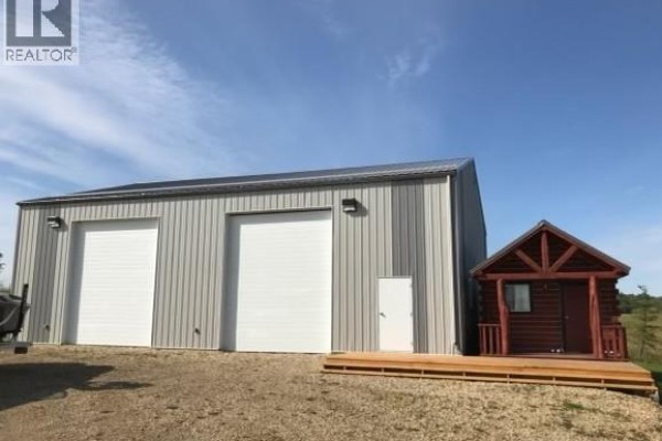 Metal workshop with two large white garage doors and a small log cabin addition. - Lot 2 - 70539 Rng Rd 250, Rural Greenview No  16, M D  Of