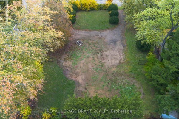 Overhead view of a cleared lot with dirt and grass, bordered by trees. - Lot #2 - 72 Ava Road, Brantford