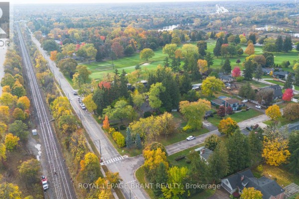 Aerial view of a street with fall foliage, showing houses, a golf course, and railway tracks. - Lot #2 - 72 Ava Road, Brantford