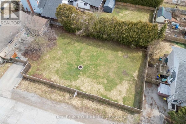 Wide aerial view of a backyard lot enclosed by a wooden fence and hedges. - Lot 2 & 3 - 108 Ontario Street, Clarington