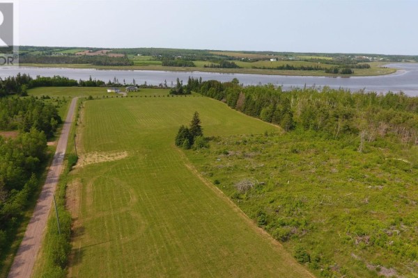 Aerial perspective of the property with grassy area, trees, and winding road alongside the river. - Lot 20-2 Patti Lane, Fort Augustus