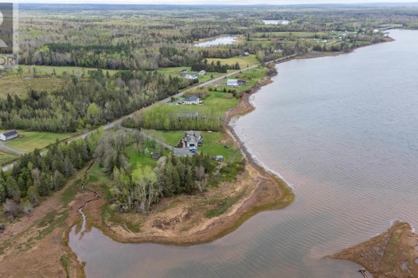 Aerial view of waterfront property with trees, a house, and a bay with marshy edges. - Lot 21-1 & 21-2 Highway 6, Wallace