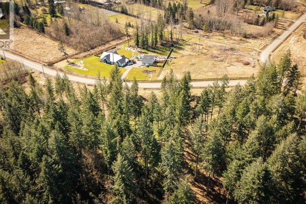 Aerial view of homes nestled among tall evergreen trees with a cleared area nearby. - Lot 21 Oyster River Way, Black Creek