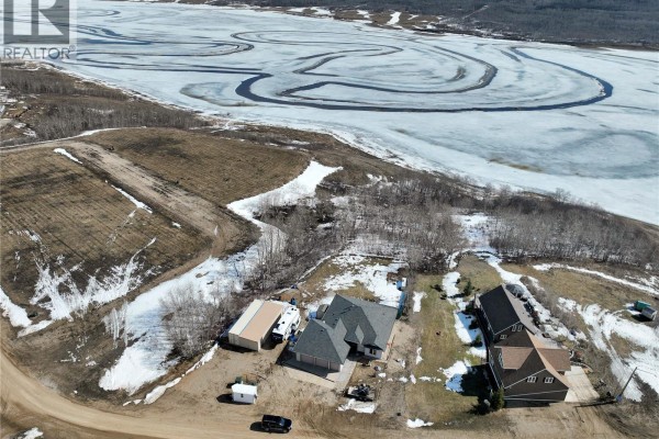 Aerial view of properties and undeveloped land with a frozen lake in the distance. - Lot 21 Pelican Landing, Lake Of The Prairies