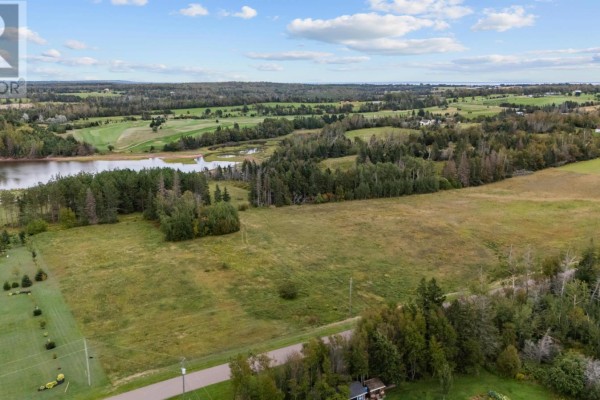 Aerial view of a large grassy lot and surrounding landscape with water and fields. - Lot 22-2 Macphail Cove Road, Fairview