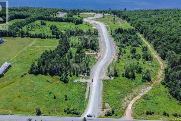 Aerial image showing a winding road through forested land, adjacent to a body of water. - Lot 22-33 Route 616, Keswick Ridge