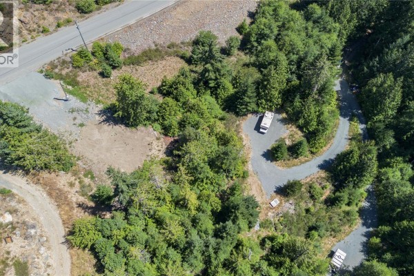 Aerial view of a cleared area on Lot 23 with a paved driveway, trees, and two recreational vehicles. - Lot 23 Goldstream Heights Dr, Shawnigan Lake