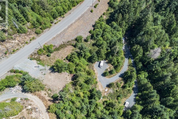Aerial view of Lot 23's property line and driveway, bordered by paved road and dense green trees. - Lot 23 Goldstream Heights Dr, Shawnigan Lake