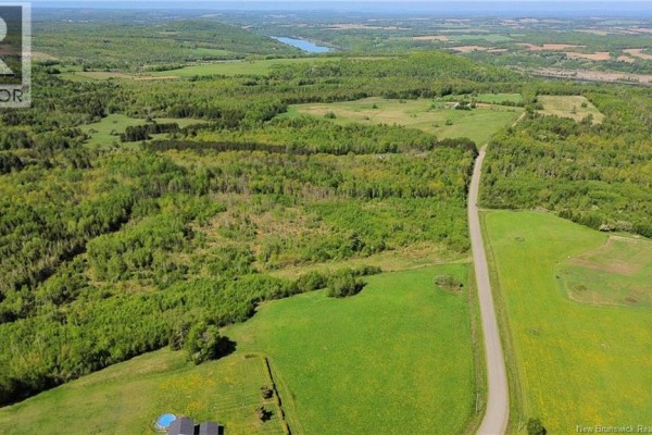 Aerial view of Lot 24-01 Mckenna Road, Newburg, with rolling green fields, dense trees, and a winding road. - Lot 24-01 Mckenna Road, Newburg