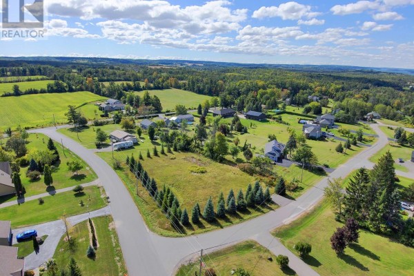 Aerial view of a residential lot at the corner of a paved road, featuring trees and surrounding homes. - Lot 26 Grandview Drive, Alderville First Nation