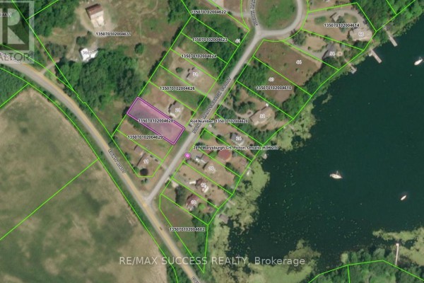 Aerial view showing multiple lots and houses along a waterfront, with the highlighted lot visible. - Lot 28 Marysburgh Court, Prince Edward County