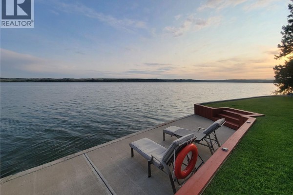 Waterfront view with chaise lounges on a concrete patio, steps leading to a grassy lawn. - Lot 3 Lakeshore Drive, Eye Hill Rm No  382