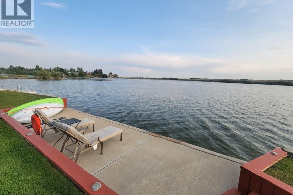 Expansive lake view at sunset with a concrete waterfront edge and steps to a grassy lawn. - Lot 3 Lakeshore Drive, Eye Hill Rm No  382