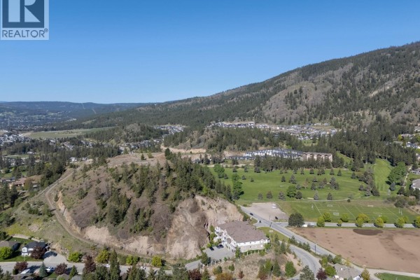 Drone shot of a partially cleared, tree-dotted lot with a view of a golf course. - Lot 3 Shannon View Drive, West Kelowna
