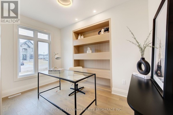 Home office with a glass desk, black chair, and built-in light wood shelving against a white wall. - Lot 35 Virtue Drive, London South