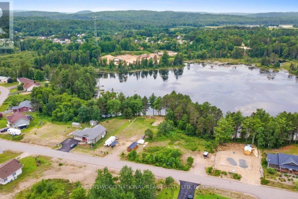 Aerial view of a lake, wooded area, and a small community with homes. - Lot 48 Lakeview Parkway, Madawaska Valley