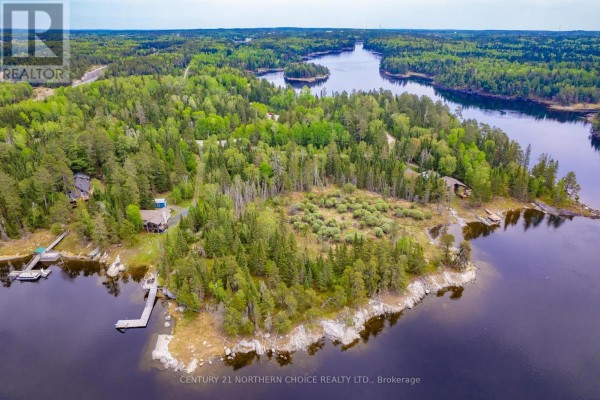 Aerial view of a lakefront property with docks, houses, and dense green trees leading to the water's edge. - Lot 5-21 Eagle Crescent, Kenora