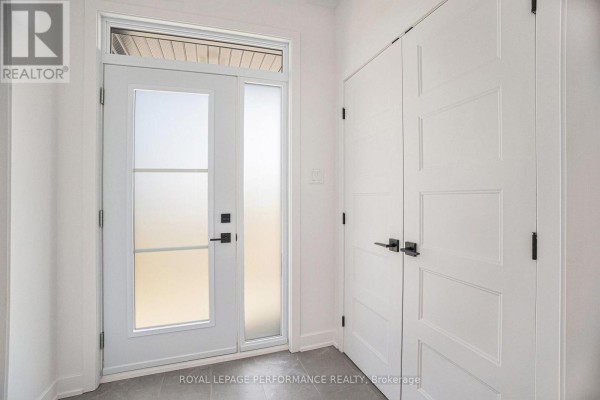 Interior entryway with a frosted glass door, beige floor tiles, and white paneled closet doors. - Lot 5 Juniper Street, The Nation