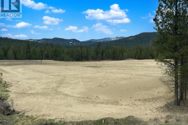 Large cleared field with sandy soil, surrounded by pine trees and mountains. - Lot 5 Parnaby Road, Cranbrook