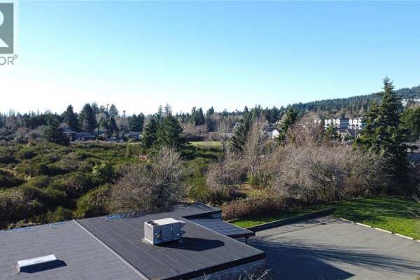 Aerial view of a flat roof and surrounding landscape, featuring trees and open land. - Lot 5 West Coast Rd, Sooke