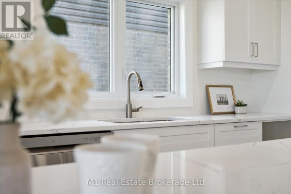 Kitchen sink area with a stainless steel faucet, white quartz countertop, and white cabinets. - Lot 51 Reids Hill Drive, Mapleton