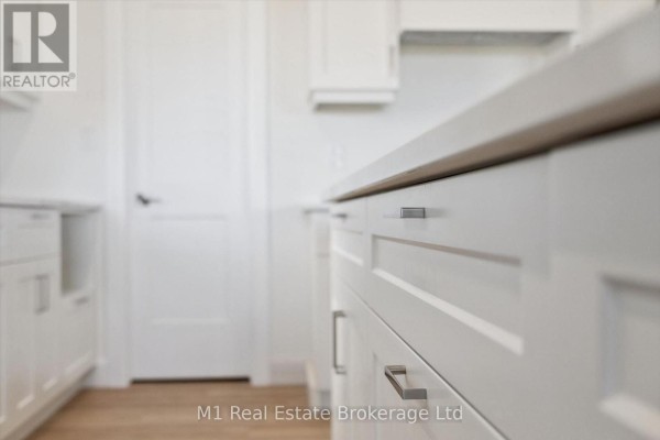 Close-up view of white kitchen cabinets with modern silver handles and white quartz countertop. - Lot 51 Reids Hill Drive, Mapleton