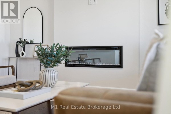 Living room with a modern fireplace, white coffee table, and decorative items. A chair is visible in the reflection. - Lot 51 Reids Hill Drive, Mapleton