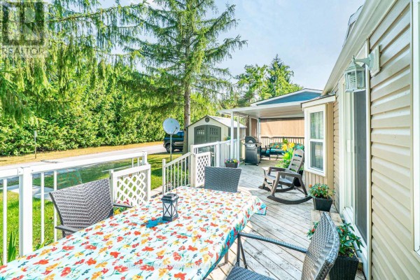 Outdoor dining area on the deck with table, chairs, and barbecue grill. - Lot 53 - 2152 Hwy 36, Kawartha Lakes