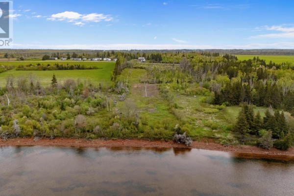 Aerial view of a cleared lot with trees and fields, bordering a calm body of water. - Lot 6 Sonora Road, St  Peters Bay