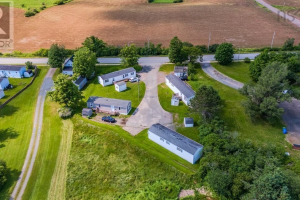 Rear view of white manufactured home with wooden deck and small shed. - Lot 7 & 8 Dalton Court, Bible Hill