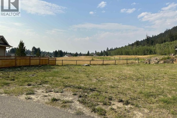 Open lot with grass and fence, scenic view of fields and trees in the background. - Lot 8-110 Forest Ridge Road, 100 Mile House