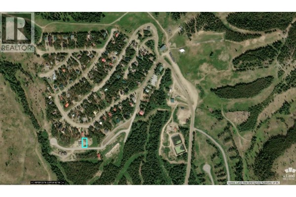 Aerial overview of a residential neighborhood with winding roads and scattered houses, bordered by forested hills and ski slopes. - Lot 8 Buck Road, Oliver