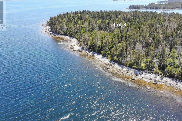 Aerial view showing Lot 8, a wooded peninsula with a rocky coastline and calm blue water. - Lot 8 Hwy 316 (grovers Pt), Cole Harbour