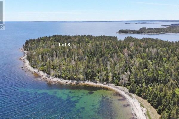 Aerial drone view of Lot 8, a large wooded lot with a rocky shoreline and ocean views. - Lot 8 Hwy 316 (grovers Pt), Cole Harbour