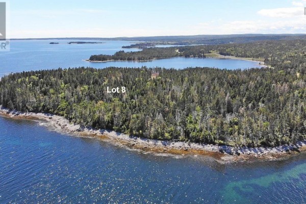 Aerial shot of Lot 8, a forested coastal property with blue water surrounding it. - Lot 8 Hwy 316 (grovers Pt), Cole Harbour