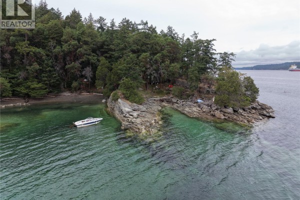 Aerial view of a small boat anchored near a rocky island with evergreen trees. - Lot 8 Ruxton Island, Ruxton Island